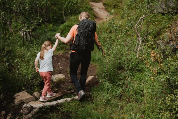 Familiefoto i skog hvor mor og datter går på tur.