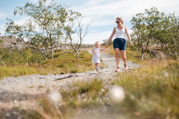 Familiefoto av mor og datter som går langs en grussti